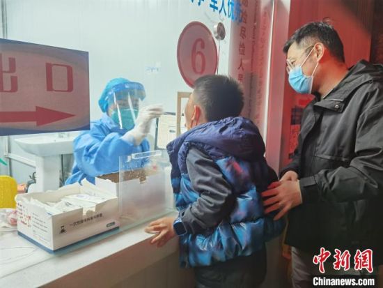 圖為家長帶著孩子進行核酸檢測采樣。　潘雨潔　攝