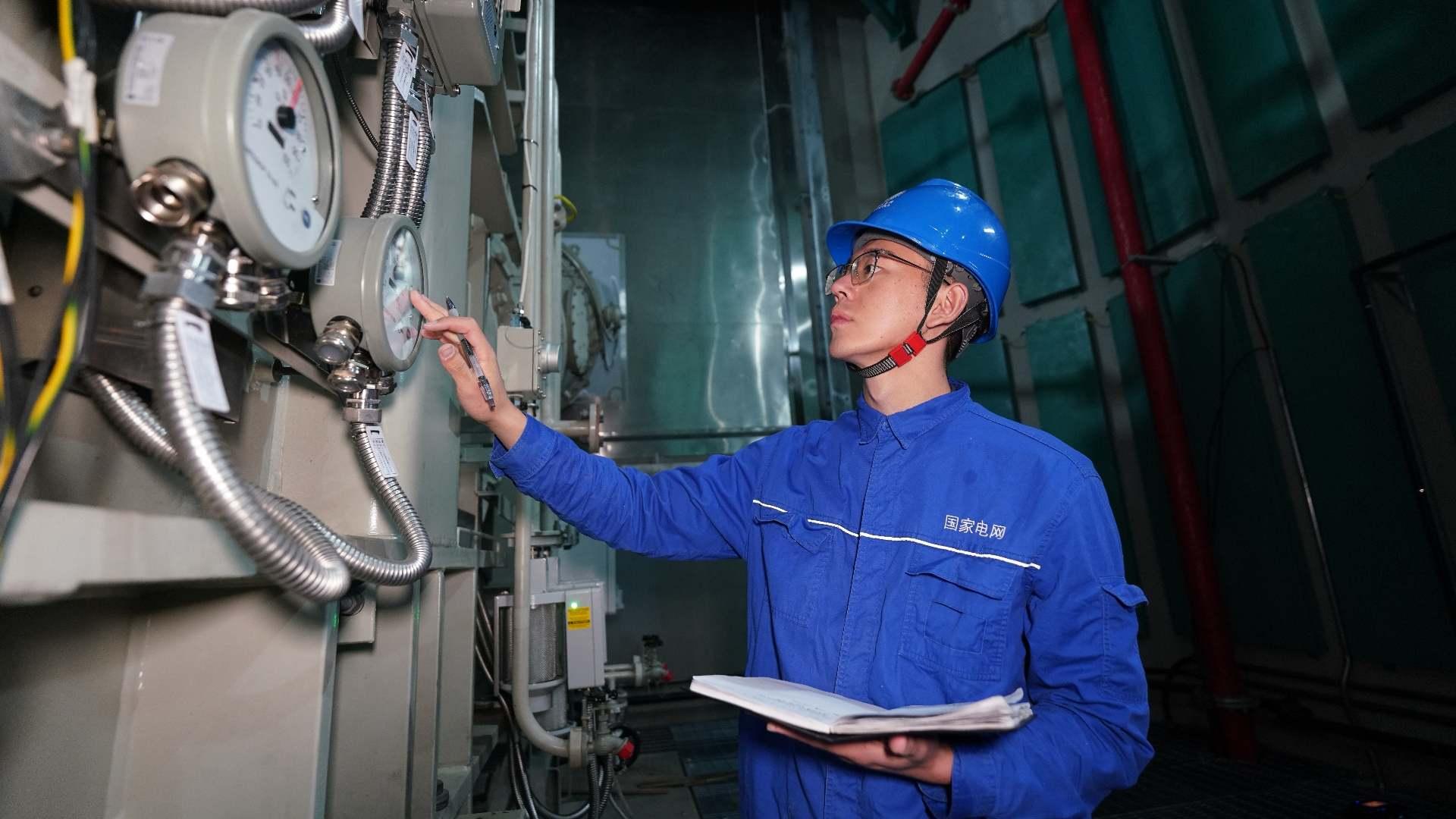 國(guó)網(wǎng)四川電力藏族員工次爾杜吉在布拖換流站檢查油表。鄭自豪攝